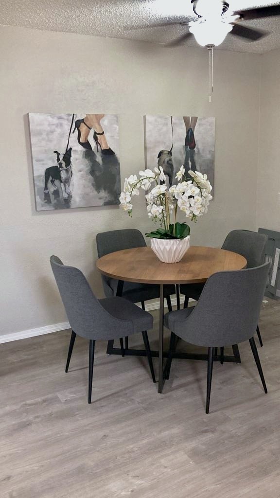 Dining area with round table, four chairs and plank flooring